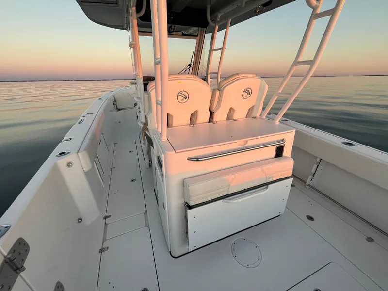 Slide: The Image of 2022 Edgewater 340CC boat interior at sunset on calm water. - 13