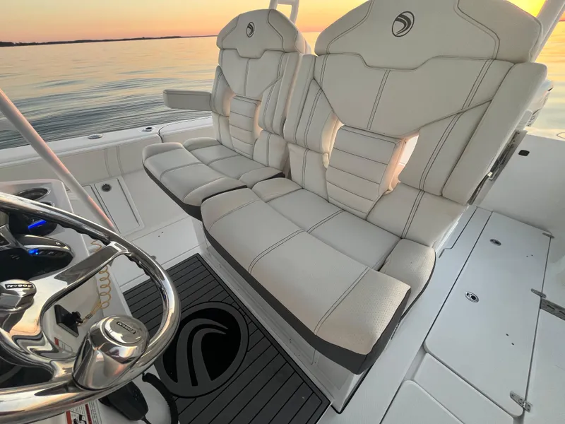 Slide: The Image of Edgewater 340CC 2022 boat interior with luxurious seating at sunset. - 21