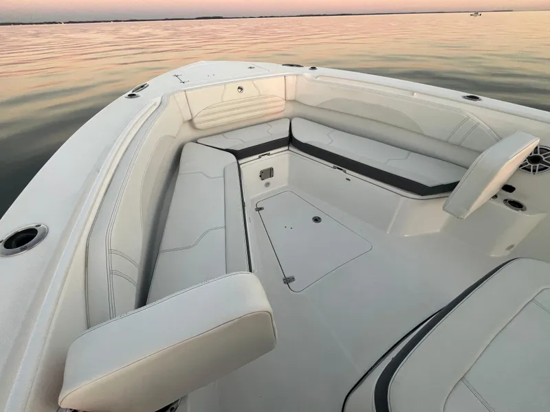 Slide: The Image of Edgewater 340CC 2022 boat interior with cushioned seating on calm water. - 24