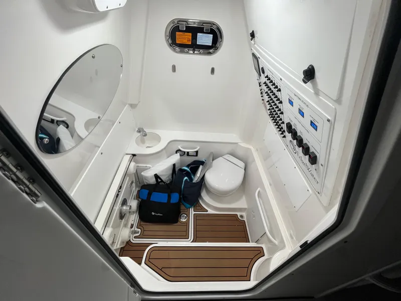 Slide: The Image of 2022 Edgewater 340CC boat interior with toilet, sink, and control panel. - 26