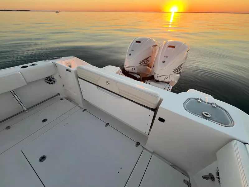 Slide: The Image of Edgewater 340CC 2022 boat at sunset with twin engines on calm water. - 27