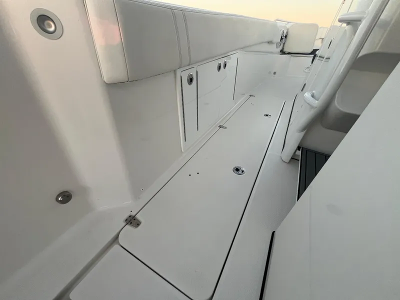 Slide: The Image of Edgewater 340CC 2022 boat interior with sleek white deck and storage compartments. - 30