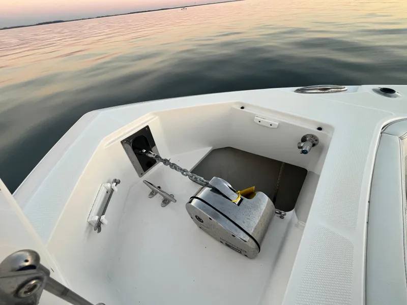 Slide: The Image of Edgewater 340CC 2022 boat anchor compartment at sunset on calm water. - 35