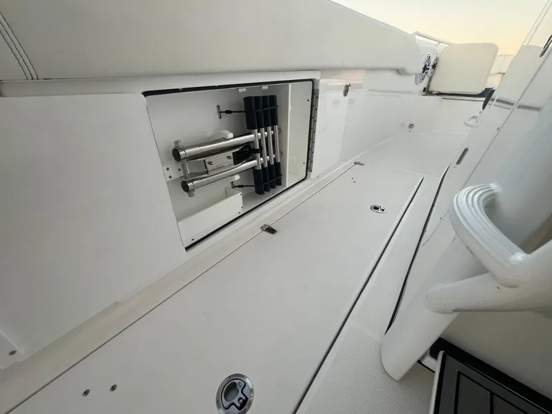 Slide: The Image of 2022 Edgewater 340CC boat interior with storage compartment and sleek white design. - 36