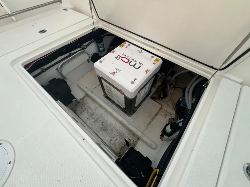 Slide: The Image of Open storage compartment of 2022 Edgewater 340CC boat with battery and wiring. - 37