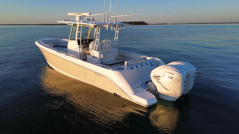 Slide: The Image of Edgewater 340CC 2022 boat on calm water at sunset. - 4