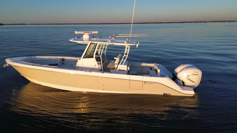 Slide: The Image of 2022 Edgewater 340CC boat on calm water at sunset. - 5