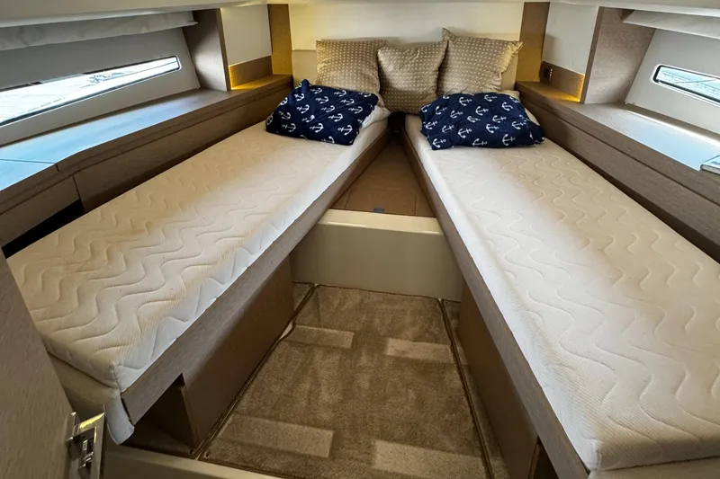 Slide: The Image of Twin beds in 2019 Prestige 460 Fly Bridge yacht cabin, with nautical-themed pillows. - 22