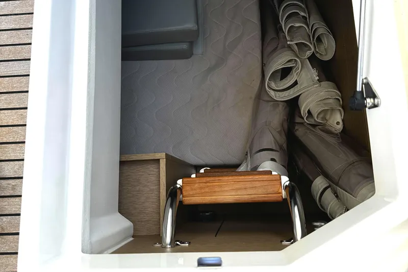 Slide: The Image of Storage compartment on 2019 Prestige 460 Fly Bridge yacht with folded canvas and wooden ladder. - 47