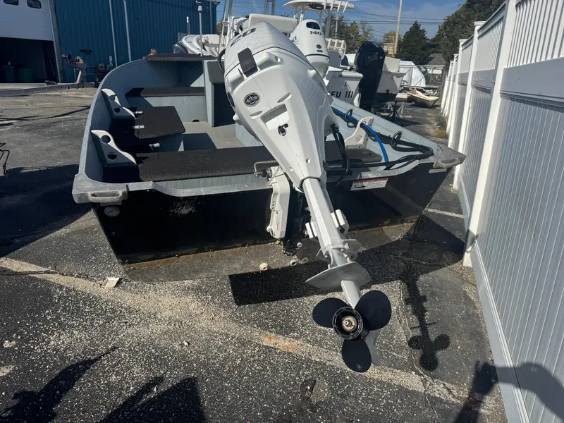 Slide: The Image of 2016 Starcraft SF 14 boat with outboard motor in a parking area. - 6