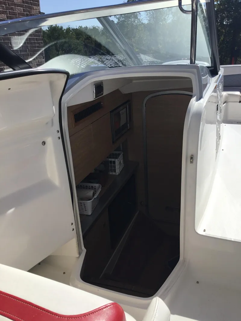 Slide: The Image of 2012 Chaparral 327 SSX boat interior with open cabin door and seating area. - 15