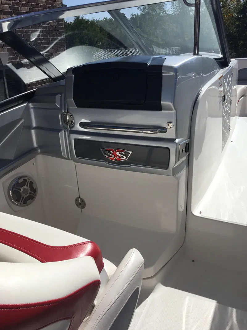 Slide: The Image of 2012 Chaparral 327 SSX boat interior with red and white seating and dashboard. - 16