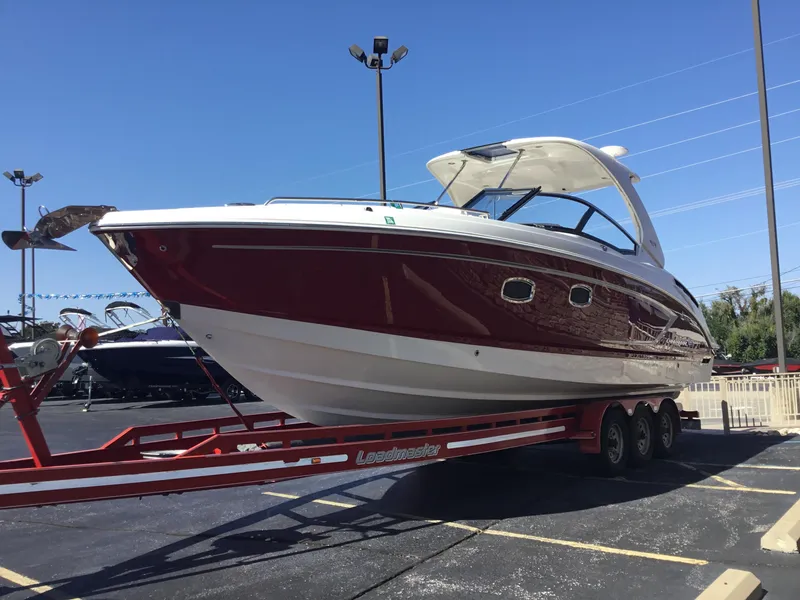 Slide: The Image of 2012 Chaparral 327 SSX boat on trailer, red and white exterior, parked outdoors. - 4