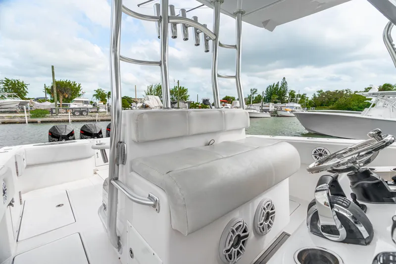 Slide: The Image of 2017 SeaHunter 39 Tournament boat interior with helm and seating, docked by the water. - 9