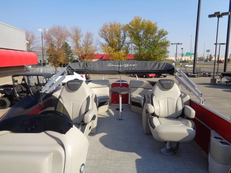 Slide: The Image of 2022 South Bay 222RS pontoon boat with spacious seating and canopy, parked outdoors. - 9