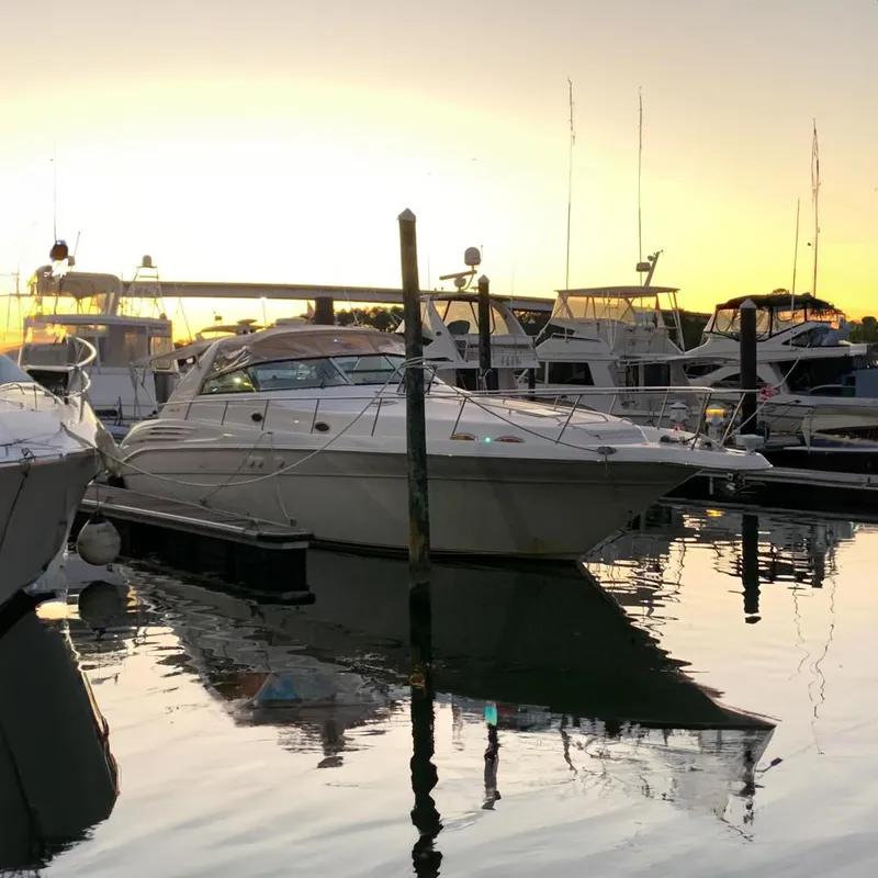 Slide: The Image of 1998 Sea Ray 450 Sundancer yacht docked at sunset in a marina. - 0