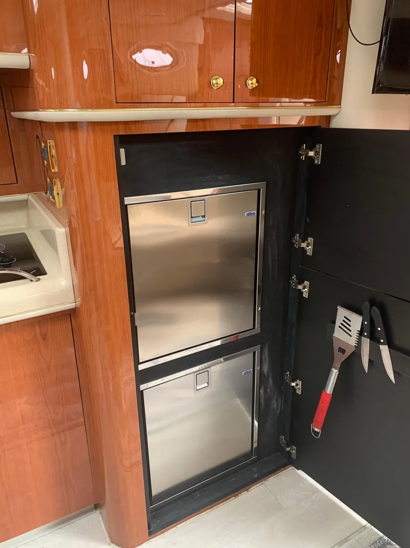 Slide: The Image of 1998 Sea Ray 450 Sundancer kitchen with stainless steel appliances and wooden cabinetry. - 17