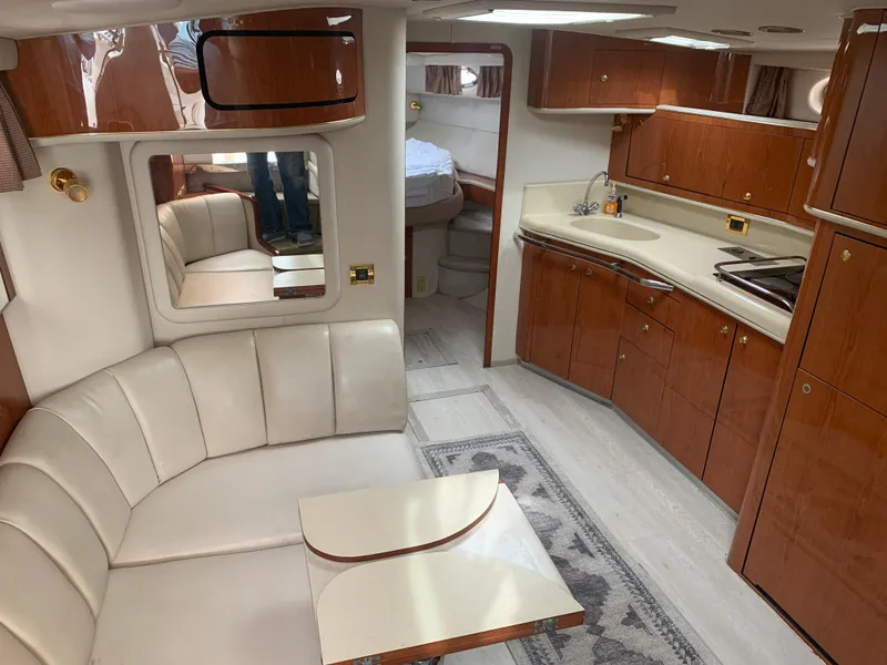 Slide: The Image of 1998 Sea Ray 450 Sundancer interior with leather seating, wooden cabinetry, and modern kitchen amenities. - 19