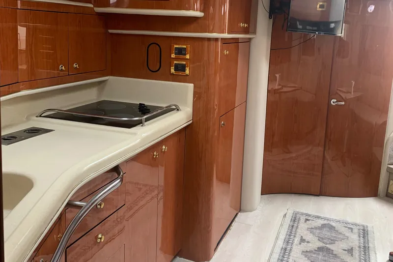 Slide: The Image of 1998 Sea Ray 450 Sundancer interior kitchen with wood cabinetry and modern appliances. - 21