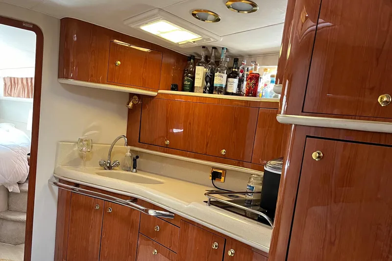 Slide: The Image of Luxurious 1998 Sea Ray 450 Sundancer yacht kitchen with wood cabinets and modern amenities. - 22