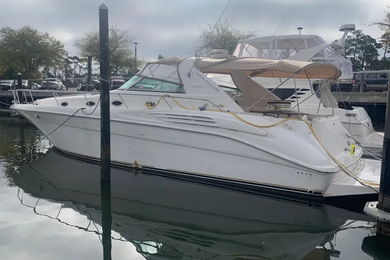 Slide: The Image of 1998 Sea Ray 450 Sundancer yacht docked in a marina, side view. - 25
