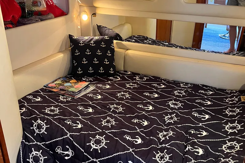 Slide: The Image of Cozy cabin interior of 1998 Sea Ray 450 Sundancer with nautical-themed bedding. - 28