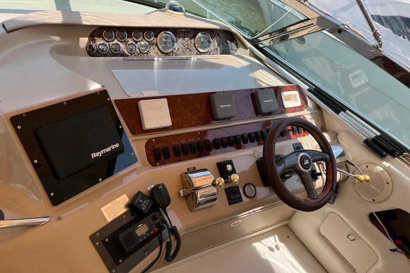 Slide: The Image of 1998 Sea Ray 450 Sundancer helm with steering wheel, gauges, and navigation equipment. - 29