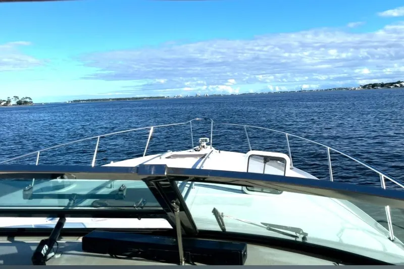 Slide: The Image of 1998 Sea Ray 450 Sundancer cruising on open water under a clear blue sky. - 3
