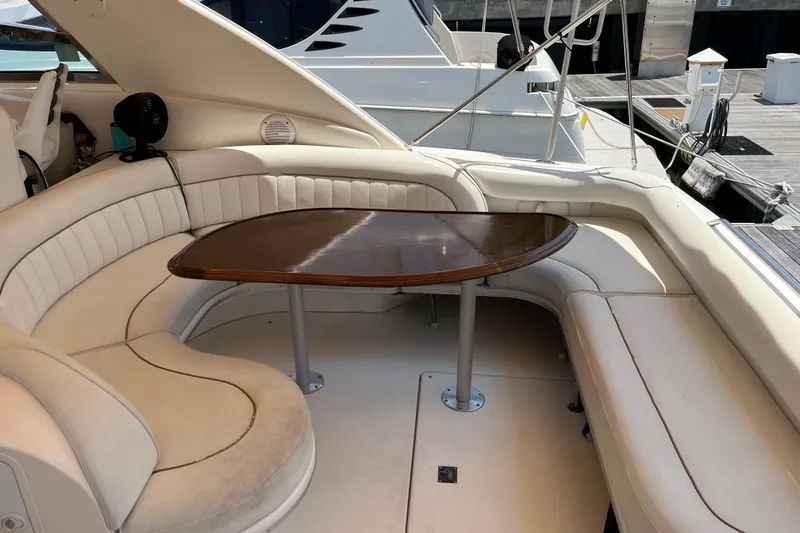Slide: The Image of 1998 Sea Ray 450 Sundancer yacht with elegant beige seating and wooden table. - 30
