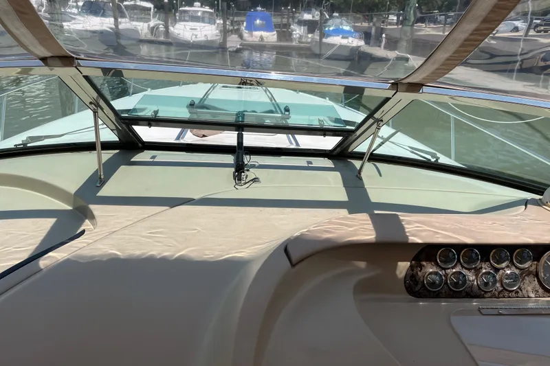 Slide: The Image of 1998 Sea Ray 450 Sundancer helm view with marina background. - 31