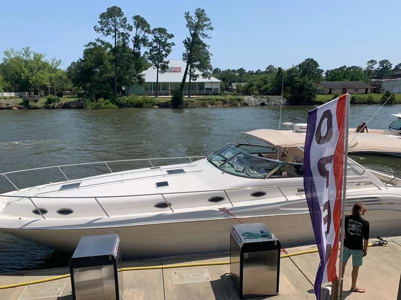 Slide: The Image of 1998 Sea Ray 450 Sundancer yacht docked by a river with trees in the background. - 33