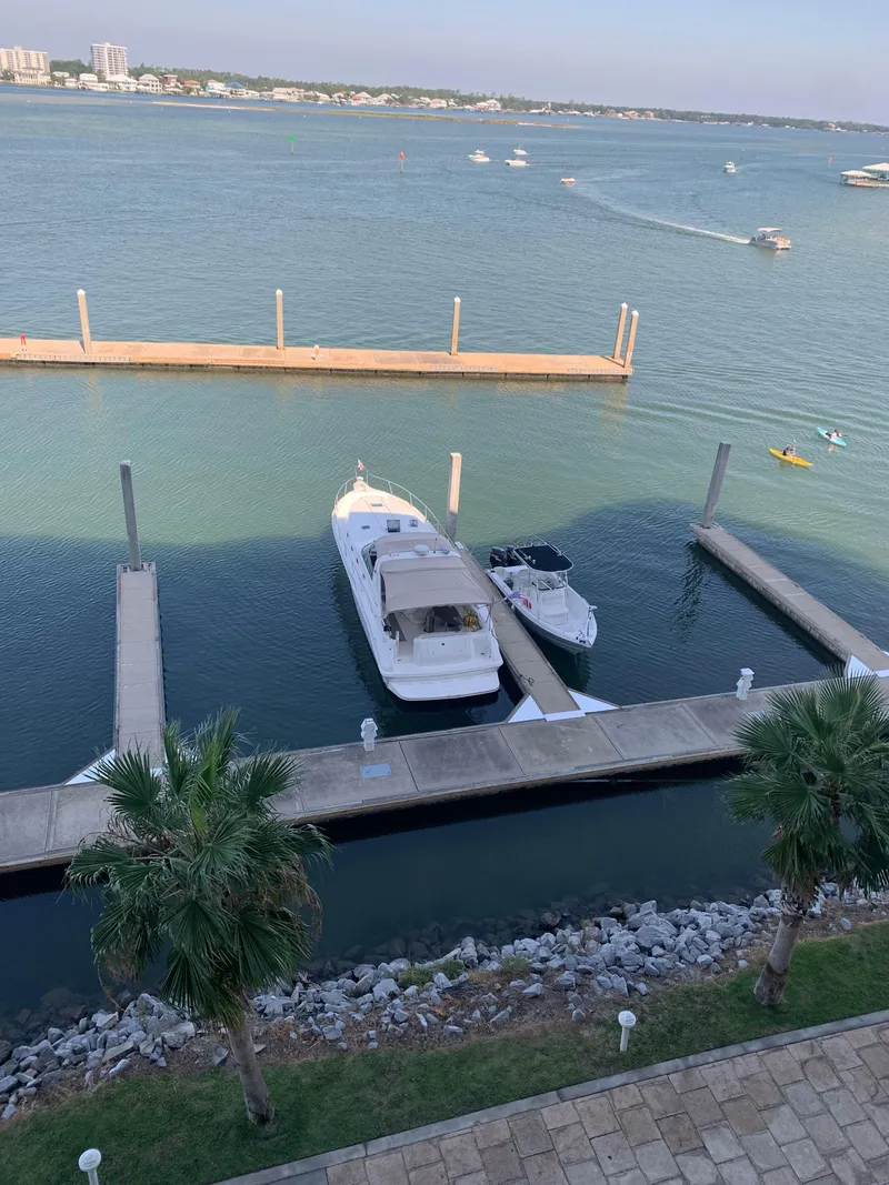 Slide: The Image of 1998 Sea Ray 450 Sundancer docked at marina with scenic waterfront view. - 35