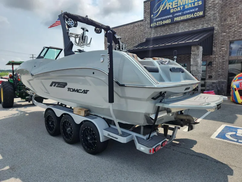 Slide: The Image of 2020 MB F24 Tomcat boat on trailer at dealership, showcasing sleek design. - 2