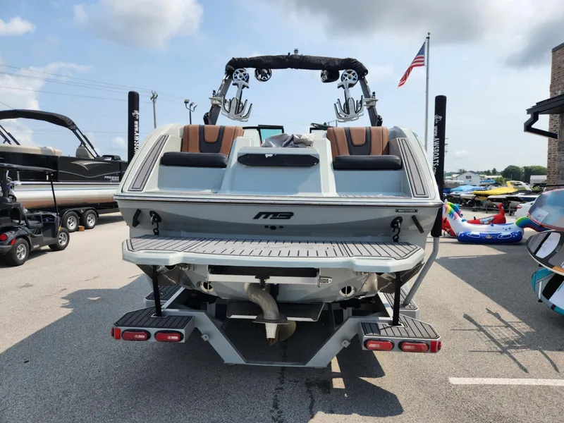 Slide: The Image of 2020 MB F24 Tomcat boat, rear view, parked outdoors with American flag. - 3