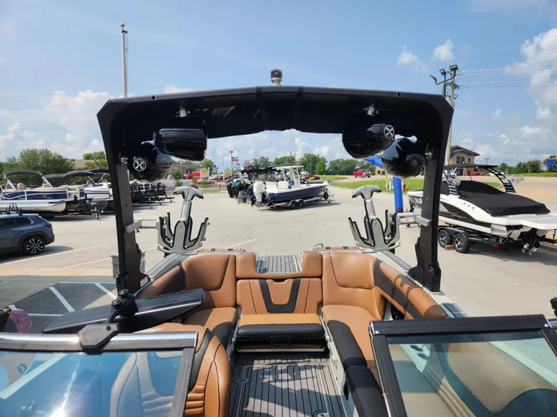 Slide: The Image of 2020 MB F24 Tomcat boat interior with brown seating and wakeboard racks. - 9