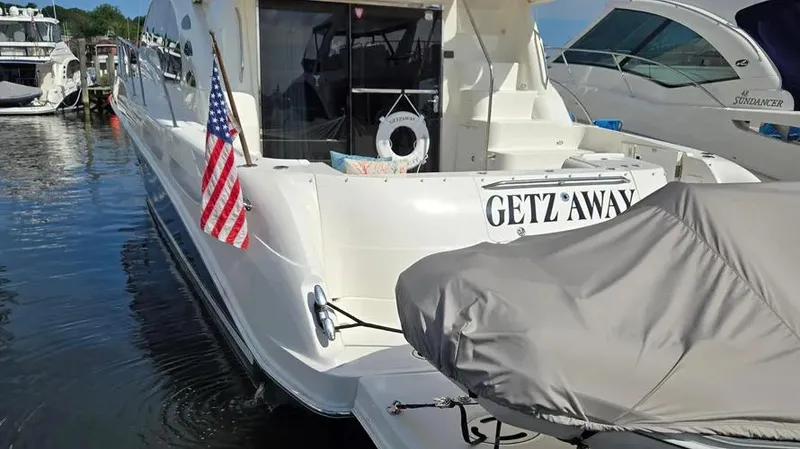 Slide: The Image of 2007 Sea Ray 580 Sedan Bridge yacht named "Getz Away" docked with American flag. - 19