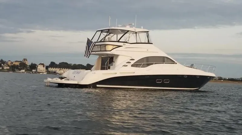 Slide: The Image of 2007 Sea Ray 580 Sedan Bridge yacht on calm water, coastal background. - 25