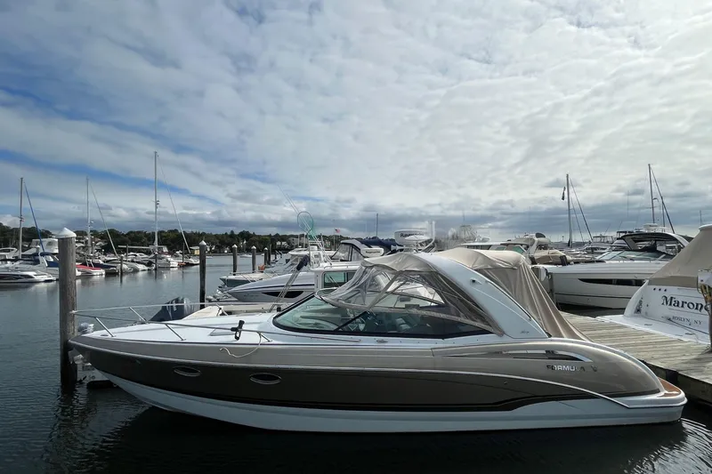 Slide: The Image of 2011 Formula 310 Sun Sport boat docked in a marina under a cloudy sky. - 2