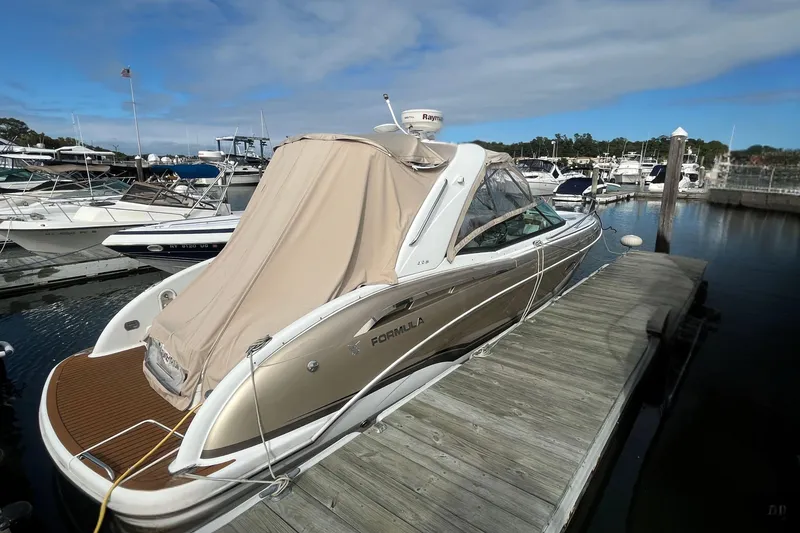 Slide: The Image of 2011 Formula 310 Sun Sport boat docked at marina under clear skies. - 3