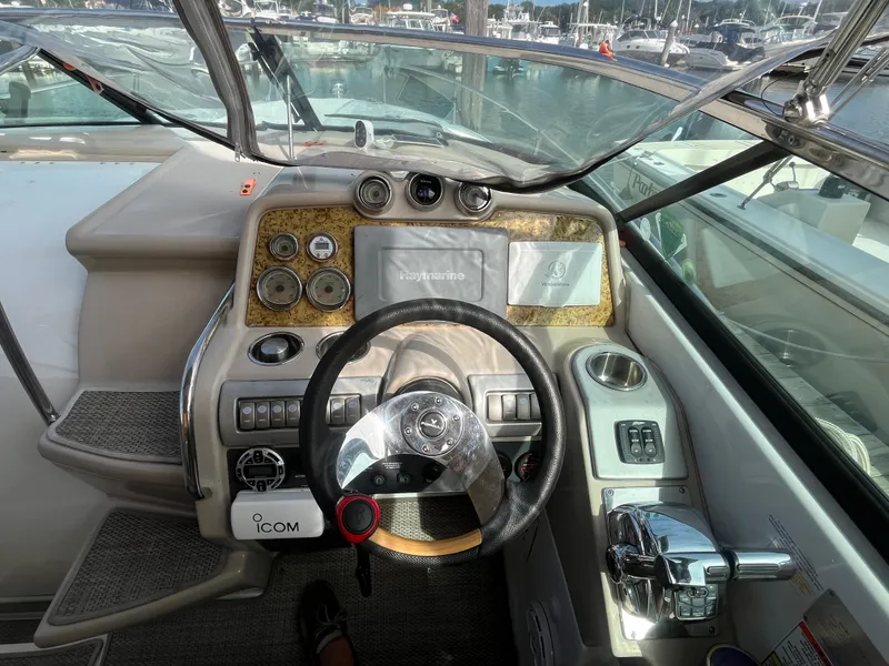 Slide: The Image of 2011 Formula 310 Sun Sport boat dashboard with steering wheel and controls. - 8