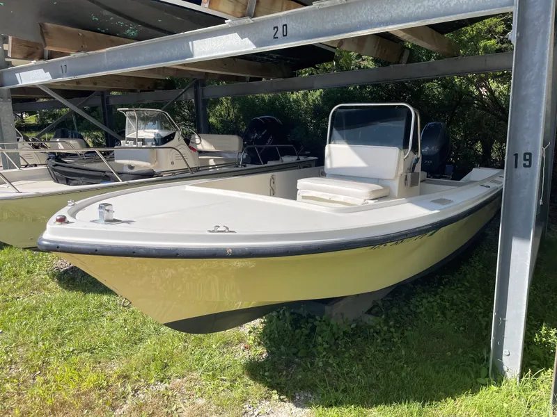 Slide: The Image of 1970 Mako 17 CC boat stored under metal shelter on grass. - 5