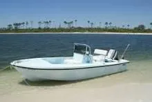 Slide: The Image of 1970 Mako 17 CC boat on sandy beach with ocean backdrop. - 9