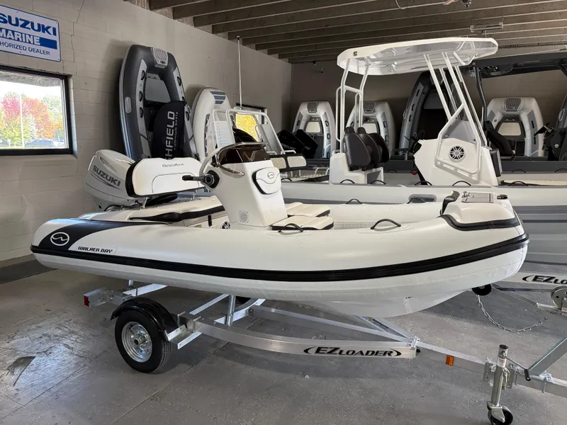 The Image of 2025 Walker Bay Generation 13 LTE boat on trailer in showroom. - 0