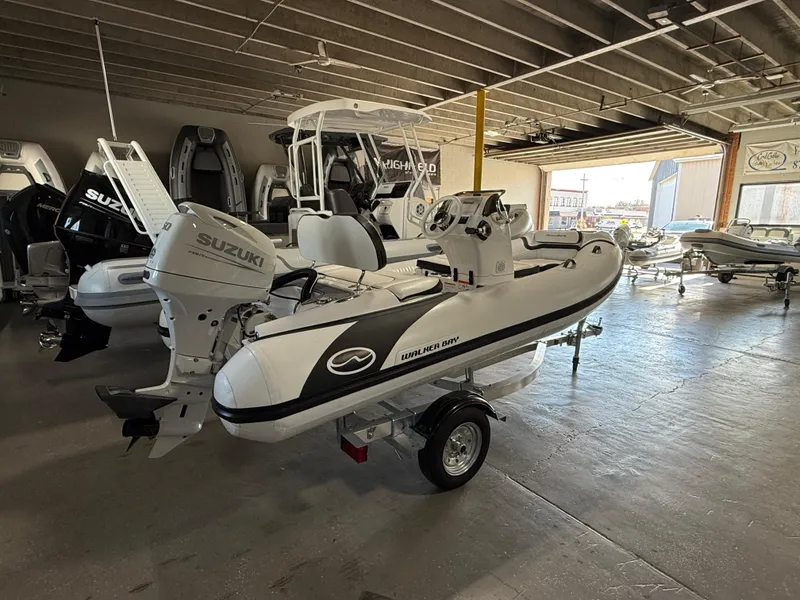 Slide: The Image of 2025 Walker Bay Generation 13 LTE boat with Suzuki engine in showroom. - 2