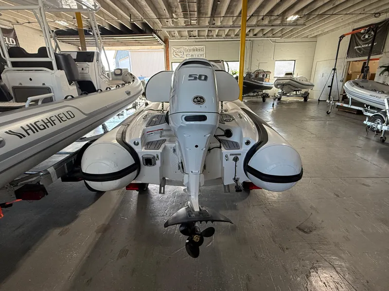 Slide: The Image of 2025 Walker Bay Generation 13 LTE boat in showroom, rear view with motor. - 3