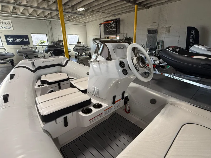 Slide: The Image of 2025 Walker Bay Generation 13 LTE boat interior with steering console and seating in showroom. - 6