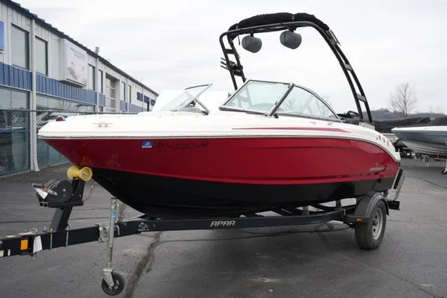 Slide: The Image of 2016 Chaparral H20 19 boat on trailer, red and white exterior, parked outdoors. - 15