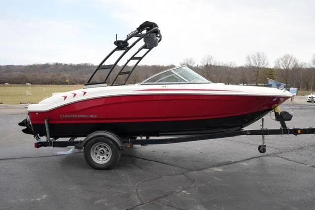 Slide: The Image of 2016 Chaparral H20 19 boat in red on trailer, parked outdoors. - 18