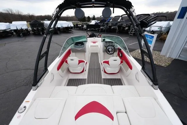 Slide: The Image of 2016 Chaparral H20 19 boat interior with red and white seating, docked outdoors. - 22