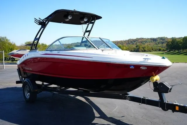 Slide: The Image of 2016 Chaparral H20 19 boat on trailer, red and white exterior, sunny day. - 3